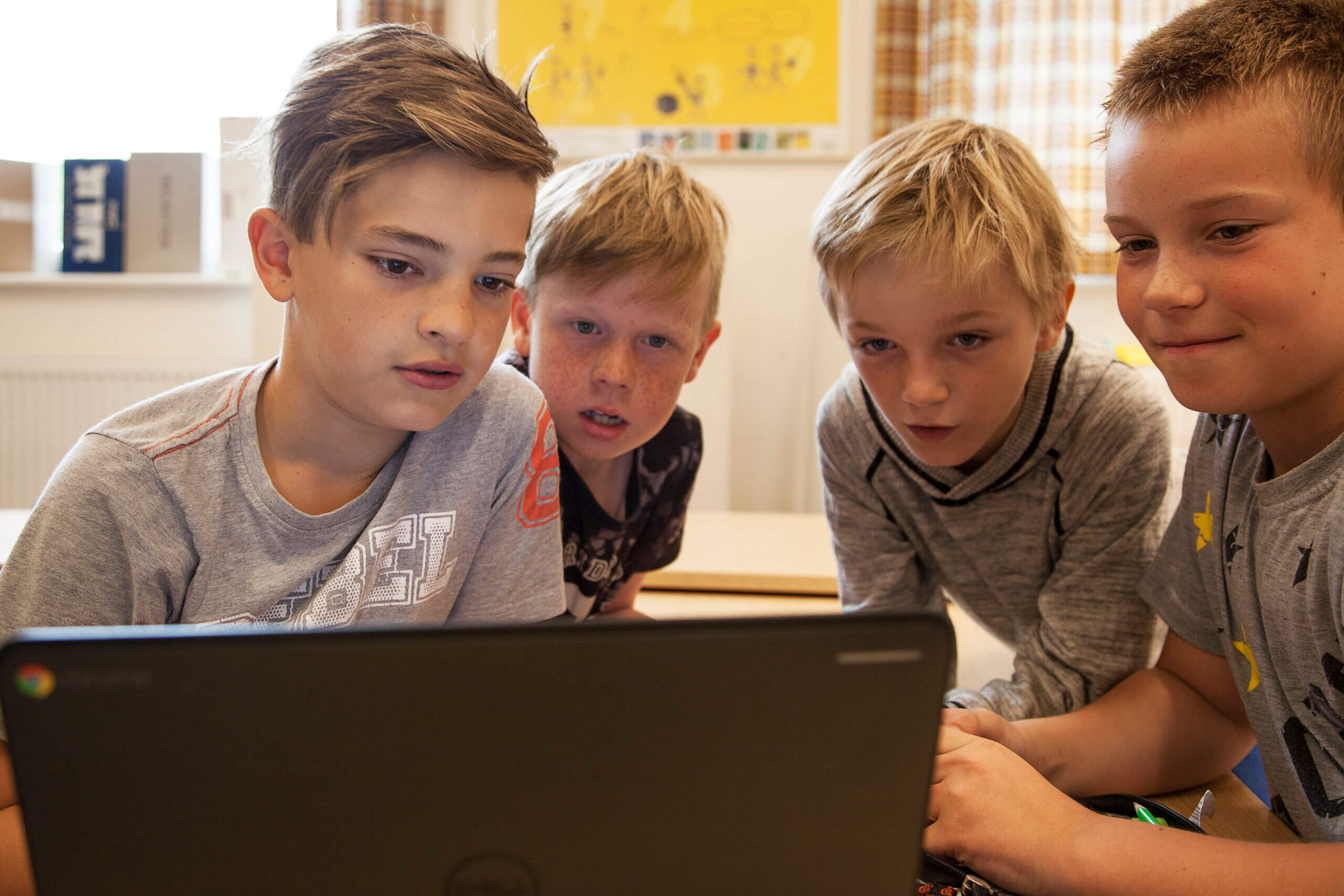 Fire drenge kigger på computer